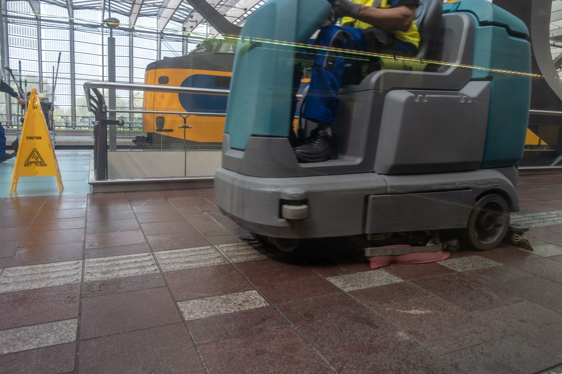 Floor cleaning machine Wet floor sign on railway platform